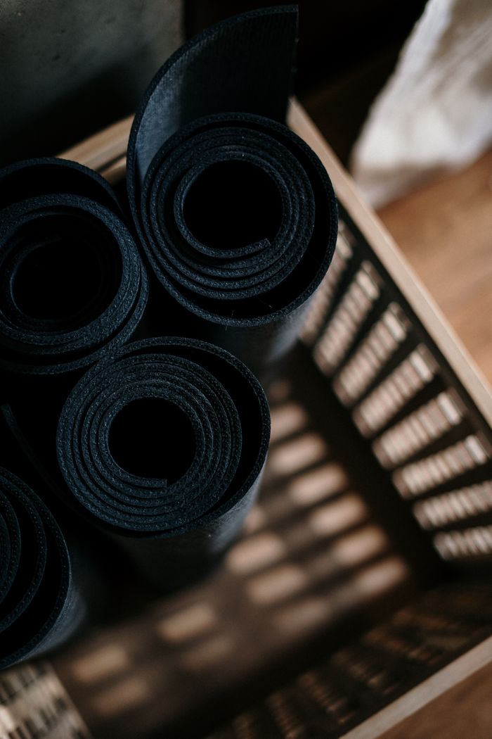 hero-img-01 Close-up of rolled yoga mats in a basket at a fitness studio, ideal for yoga or pilates.